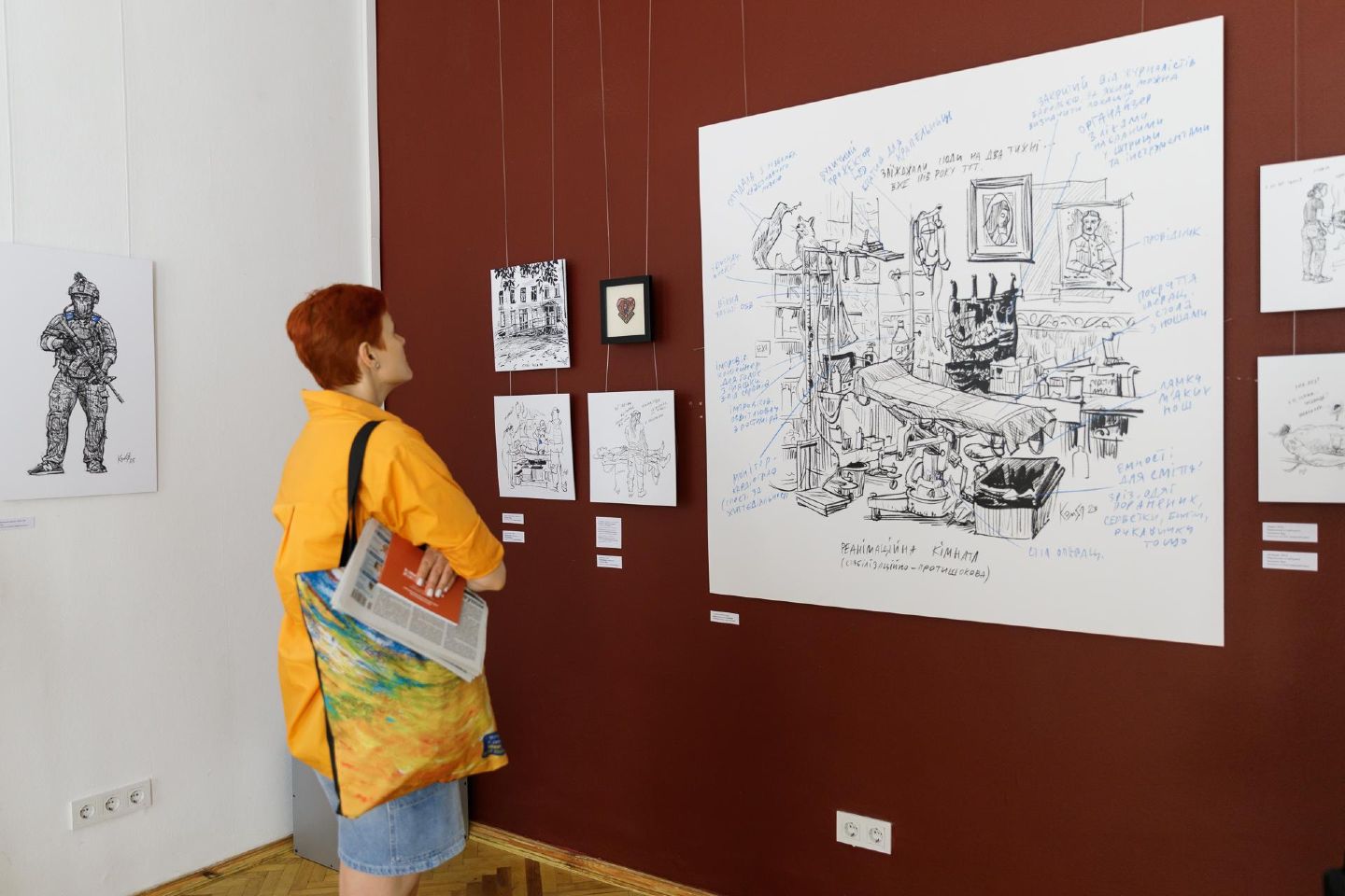 Відвідувачі розглядають роботи митця Олександра Ком'яхова